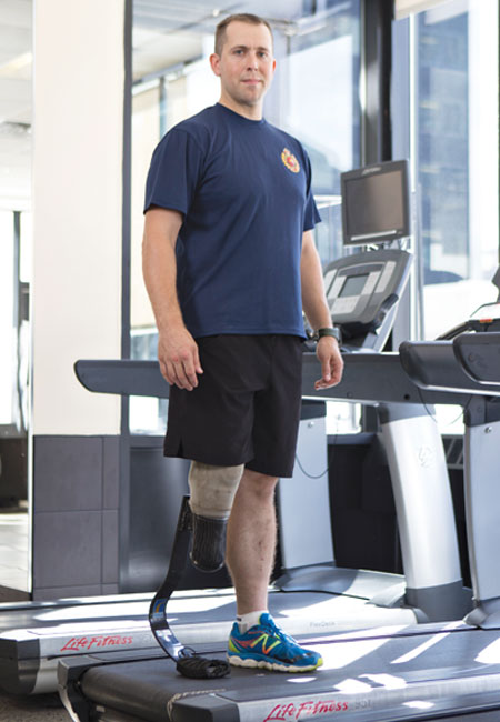 Un homme amputé d’une jambe portant une prothèse de course se tient debout sur un tapis roulant immobile.