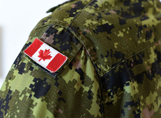 Gros plan de l’épaule d’un uniforme des Forces armées canadiennes muni d’un écusson du drapeau canadien.