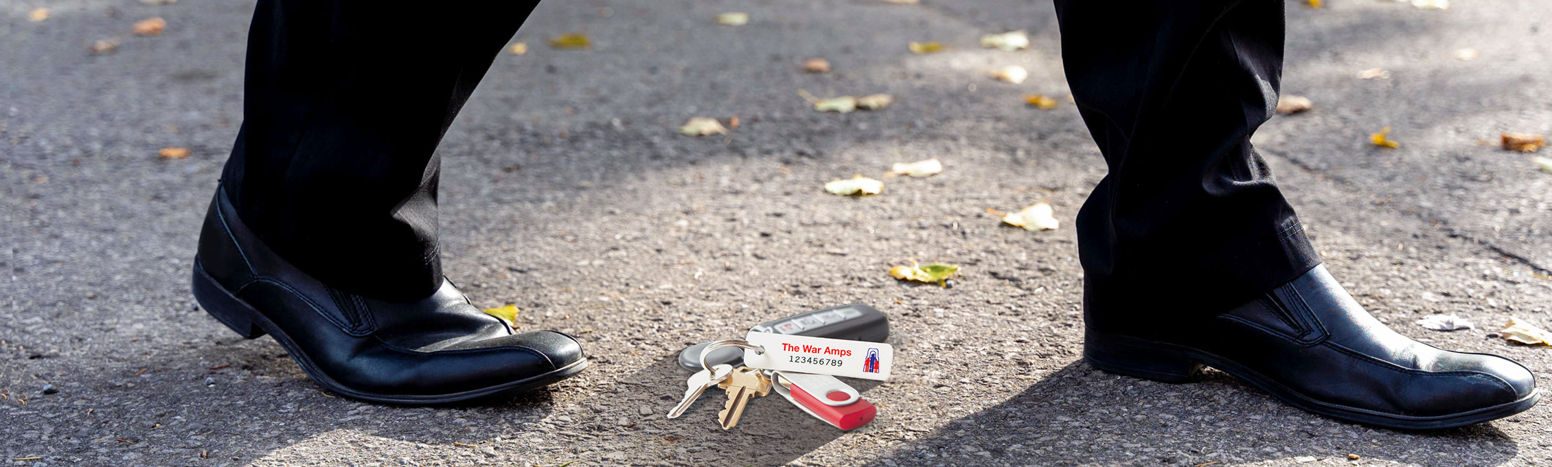 A set of keys with a War Amps key tag attached laying on the ground. Learn more about the Key Tag Service.