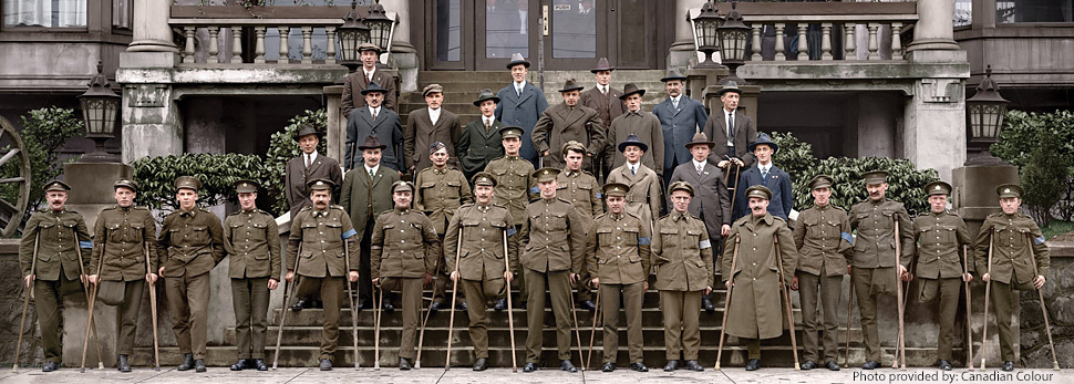 Group of war amputees (some in military uniforms and others in civilian clothing) posing in front of a building.