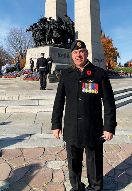 Un ancien combattant amputé se tient debout devant le Monument commémoratif de guerre du Canada à l’occasion du jour du Souvenir.