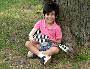 A young male arm amputee plays a ukulele.