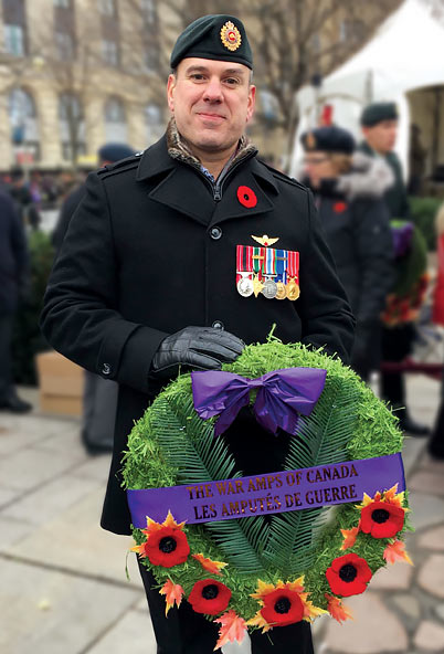 Gaétan, un sergent à la retraite, qui est amputé d’une jambe, dépose une couronne lors d’une cérémonie du jour du Souvenir.