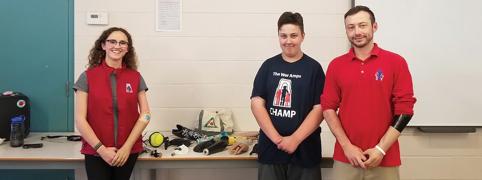 Champ Cooper and two War Amps staff standing in a classroom where they gave a PLAYSAFE presentation.