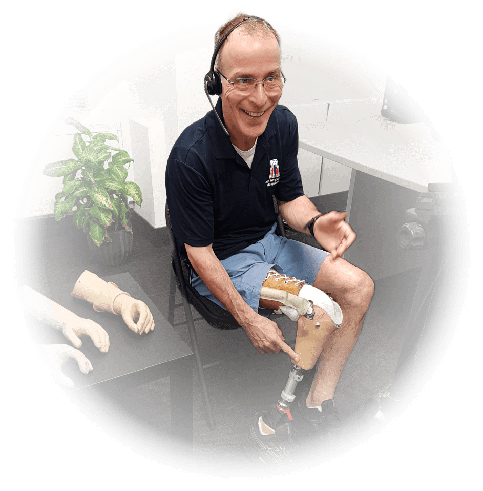 Un homme amputé d’une jambe montre du doigt son membre artificiel pendant une présentation virtuelle.